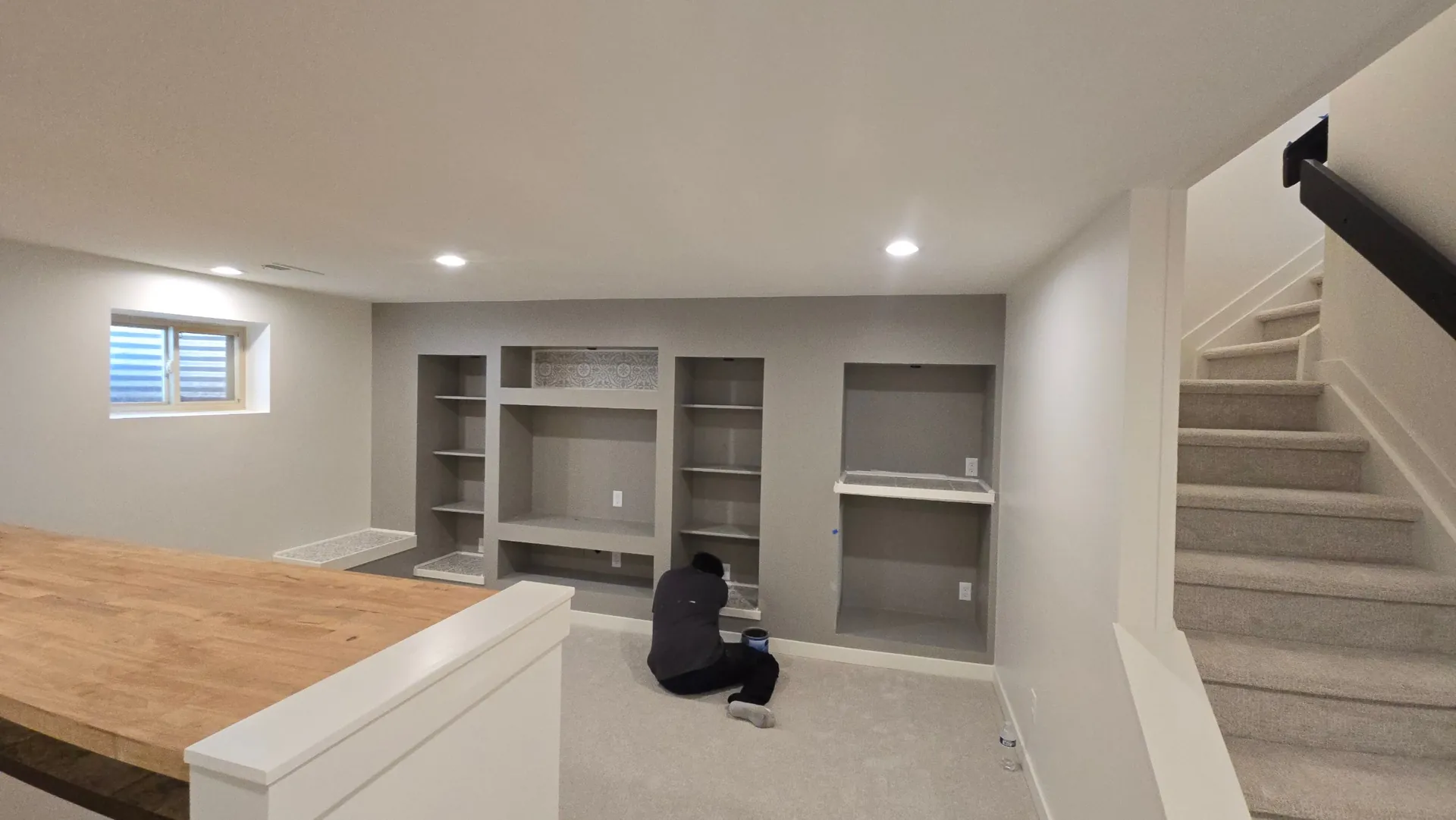 Finished basement with built-in shelving and recessed lights in Golden, CO