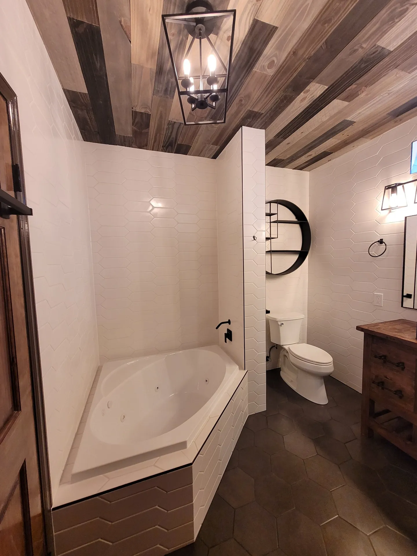 Bathroom remodel with jetted corner tub, white tile and wood plank ceiling in Golden, CO