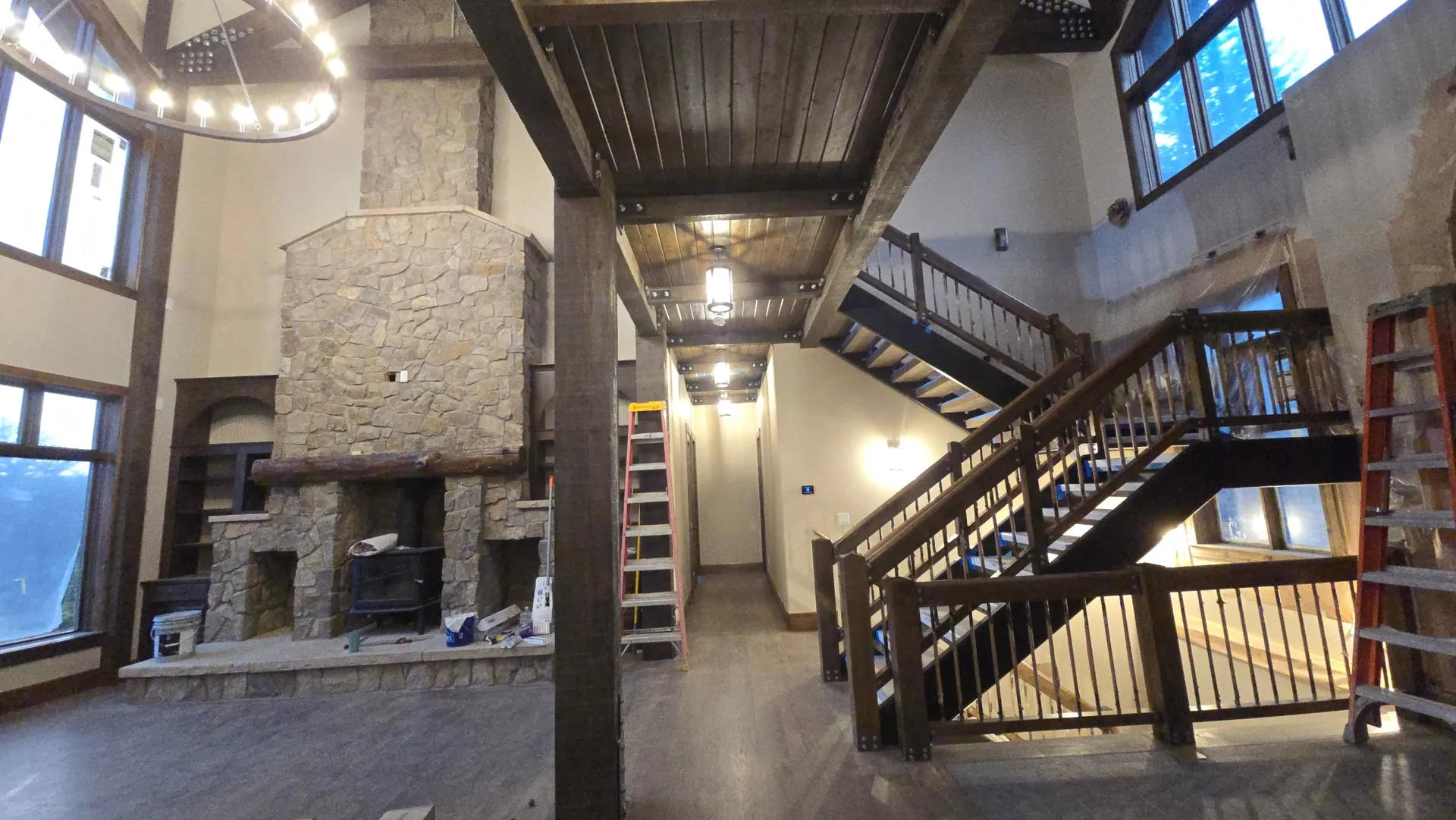 Great room with stone fireplace and open staircase near Golden, CO