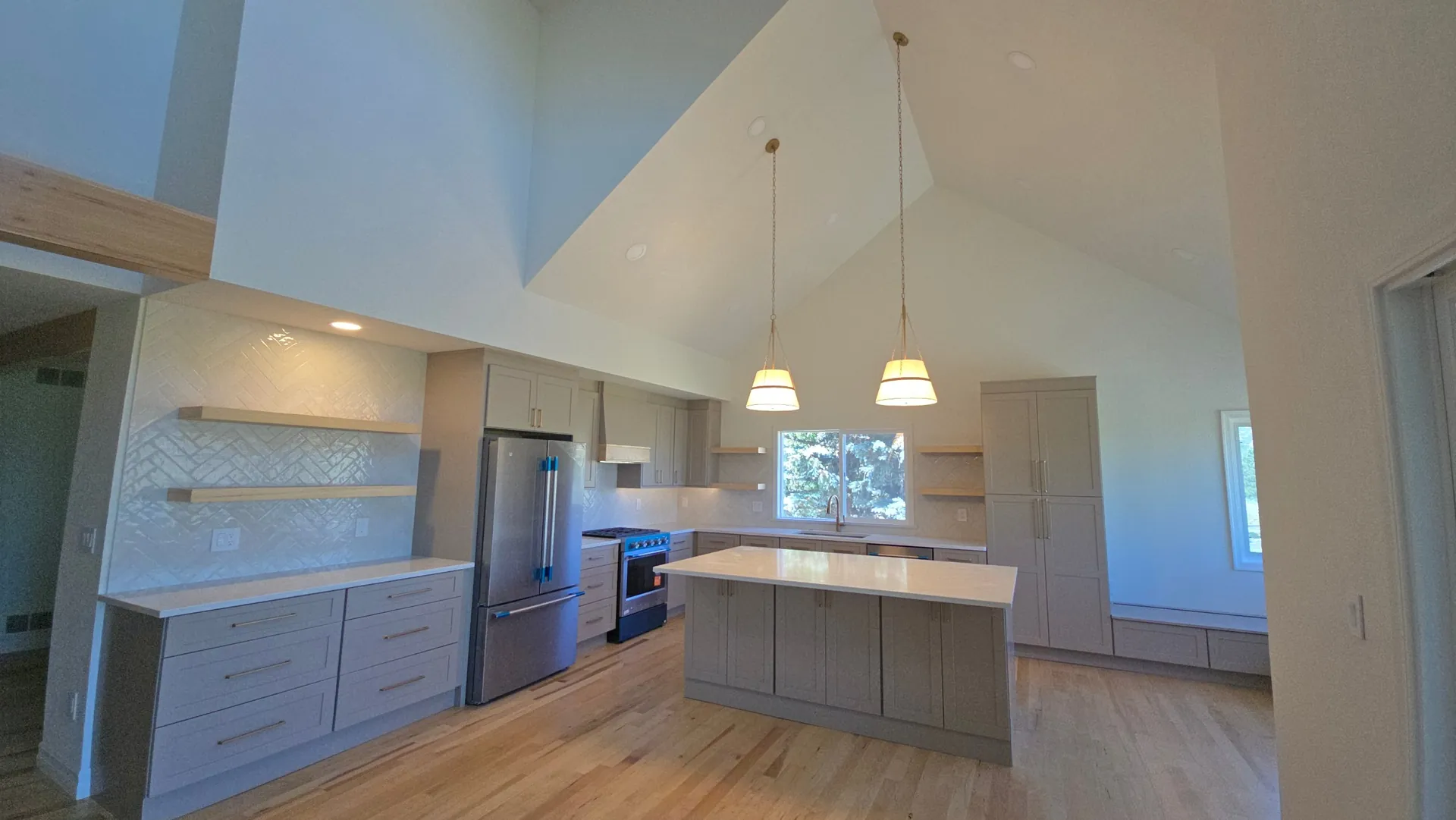 Finished kitchen remodel with vaulted ceiling, island and herringbone backsplash in Golden, CO