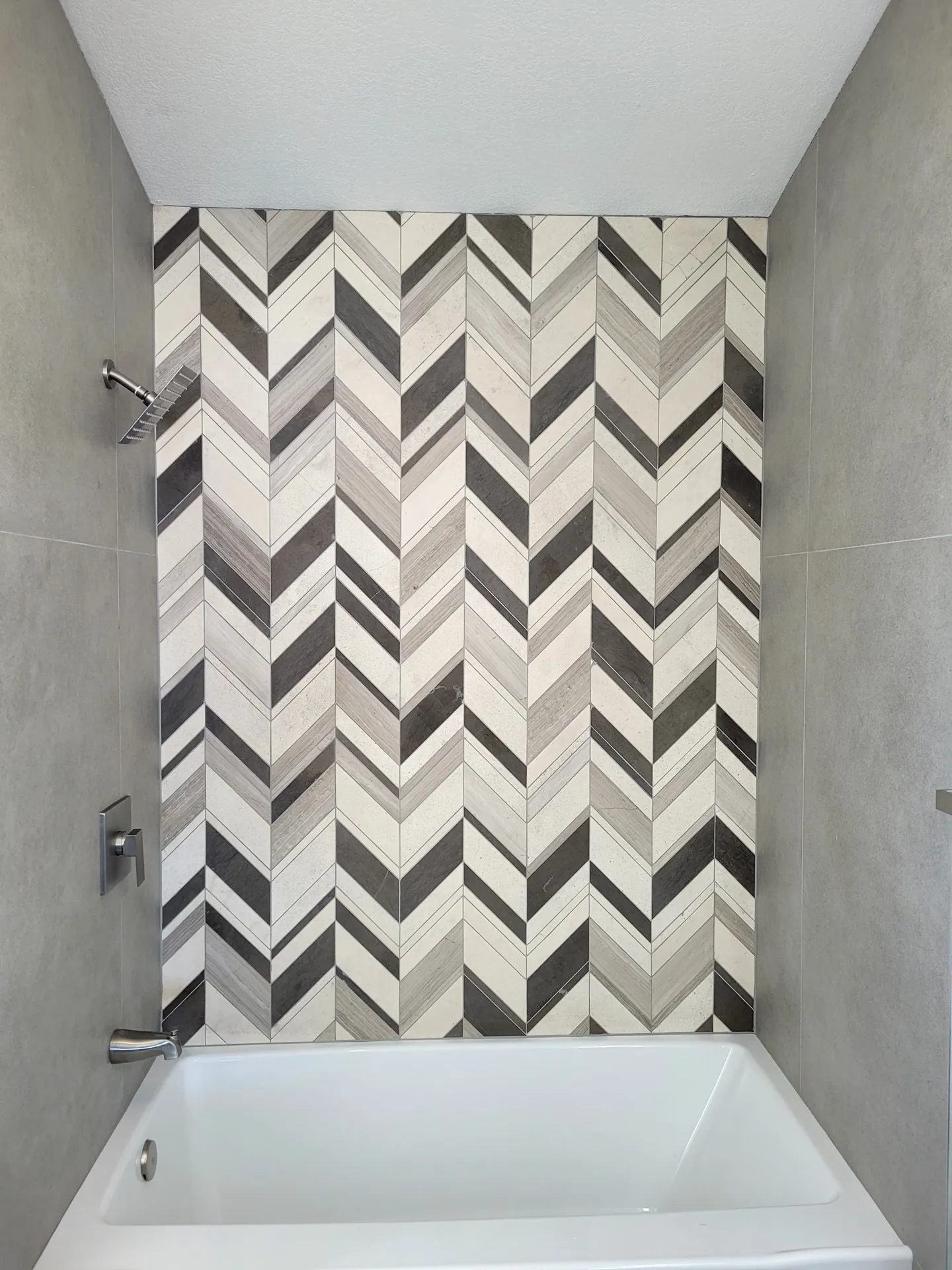 Bathtub with chevron stone tile surround in Golden, CO
